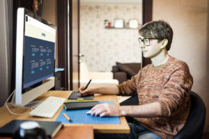 young man at home using a computer, freelance developer or designer working at home.